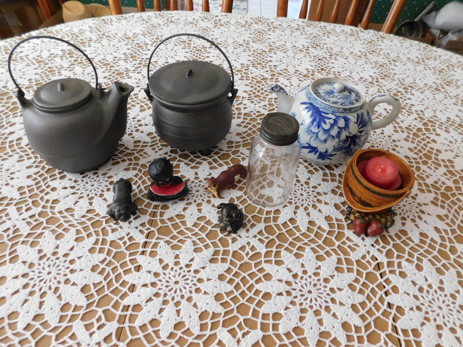 A table with a lace tablecloth and various objects on it