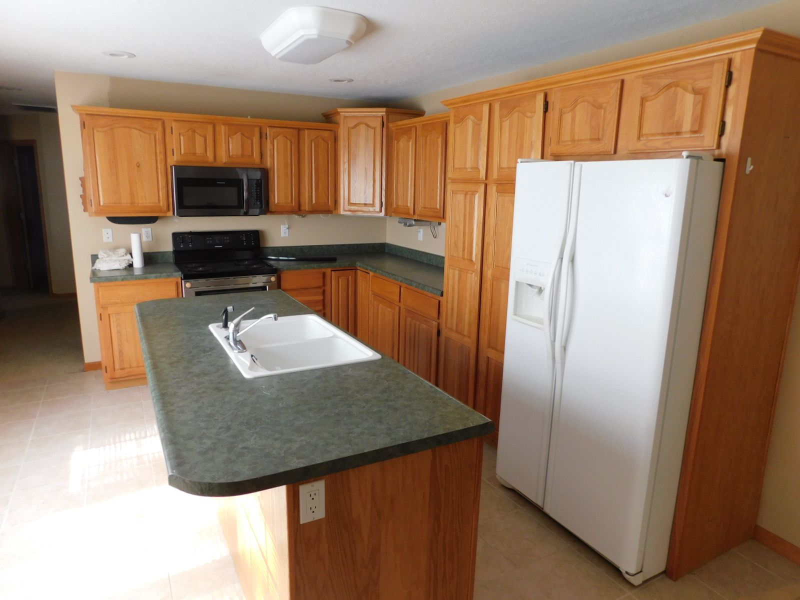 A kitchen with wooden cabinets and a white refrigerator