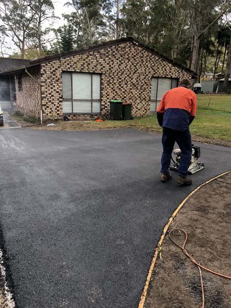man flattening asphalt