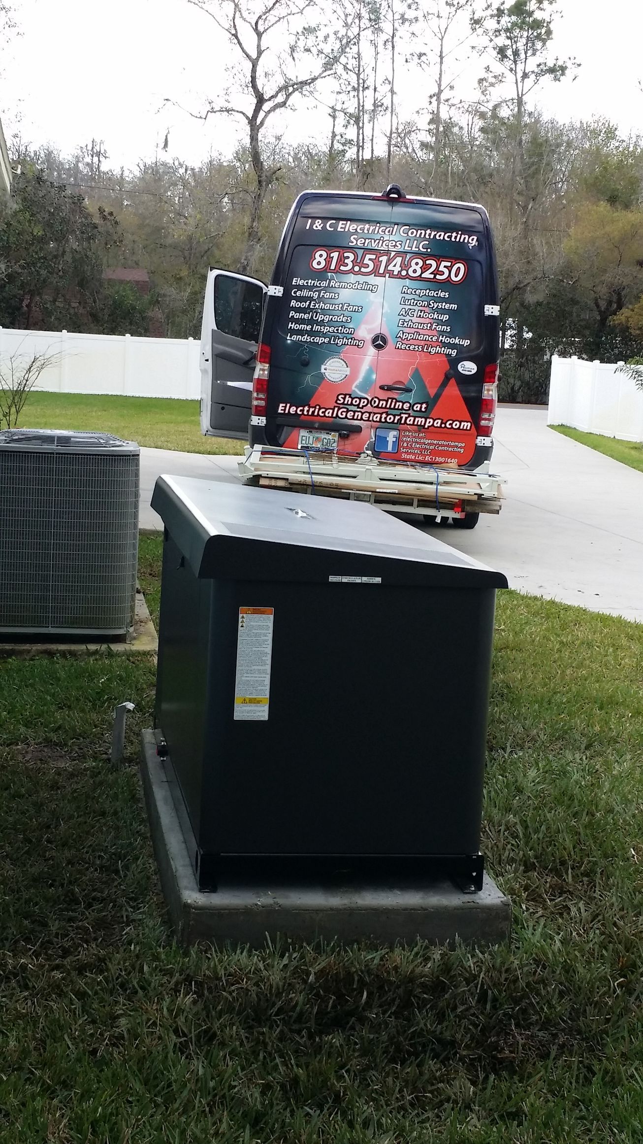 Black electrical box on a concrete base, a service van parked behind it.