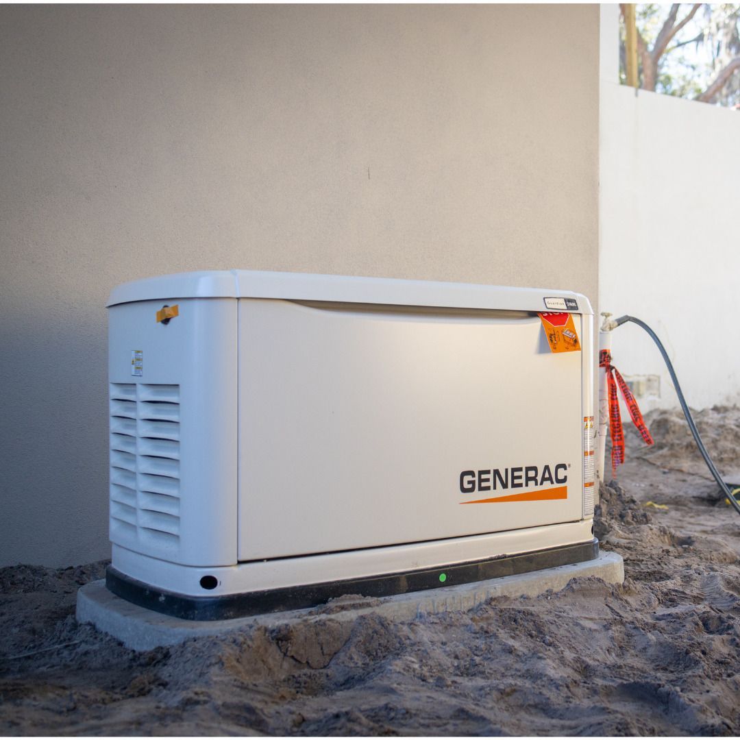 White Generac generator on a concrete pad near a building's wall, in an outdoor setting.