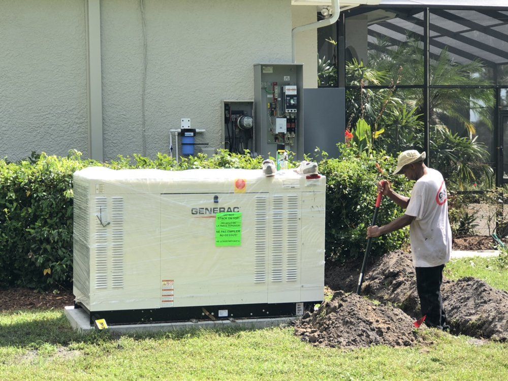 Worker installing a Generac generator on a concrete pad near a house, digging a trench.
