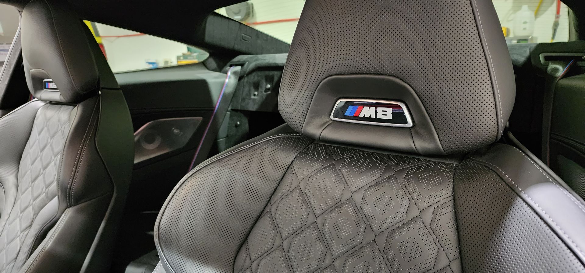 A close up of a car seat with a bmw logo on it.