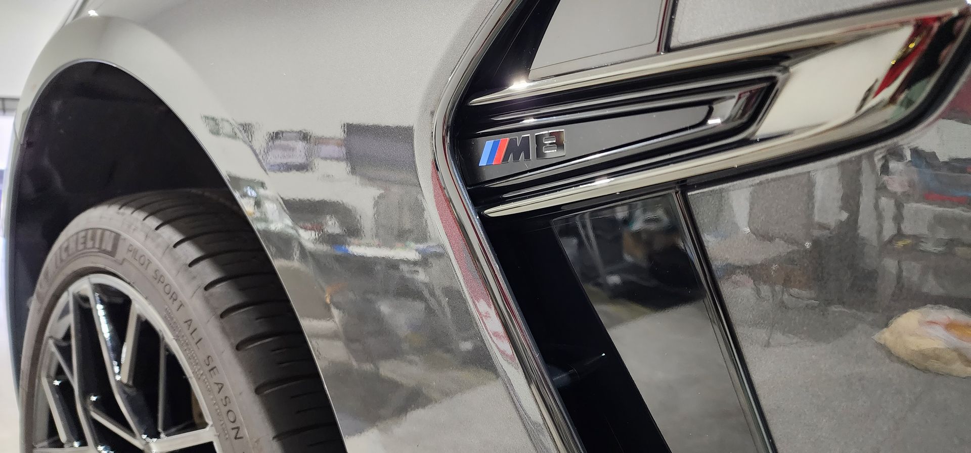 A close up of a car 's fender and tire in a garage.