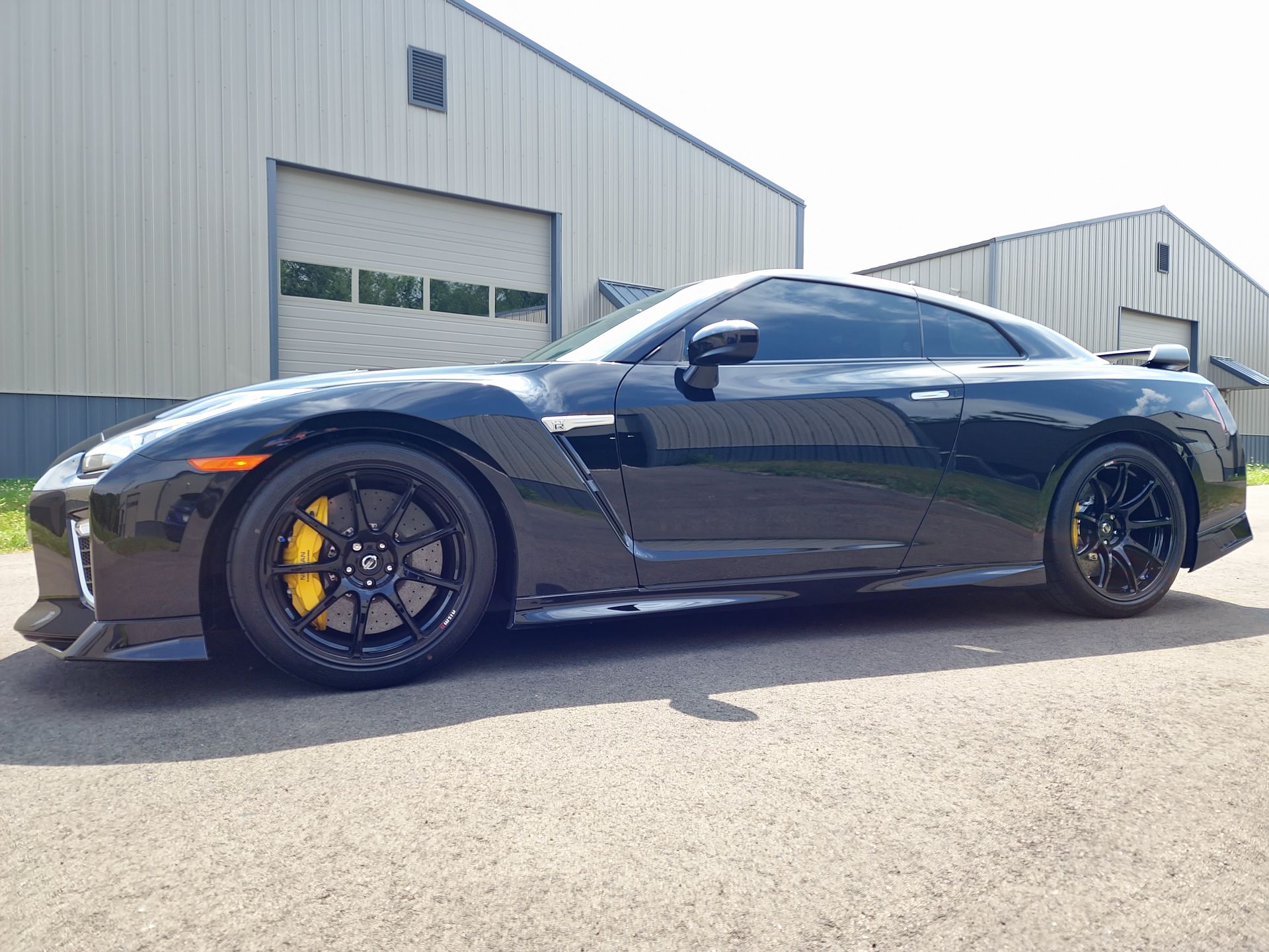 A black sports car is parked in front of a building.