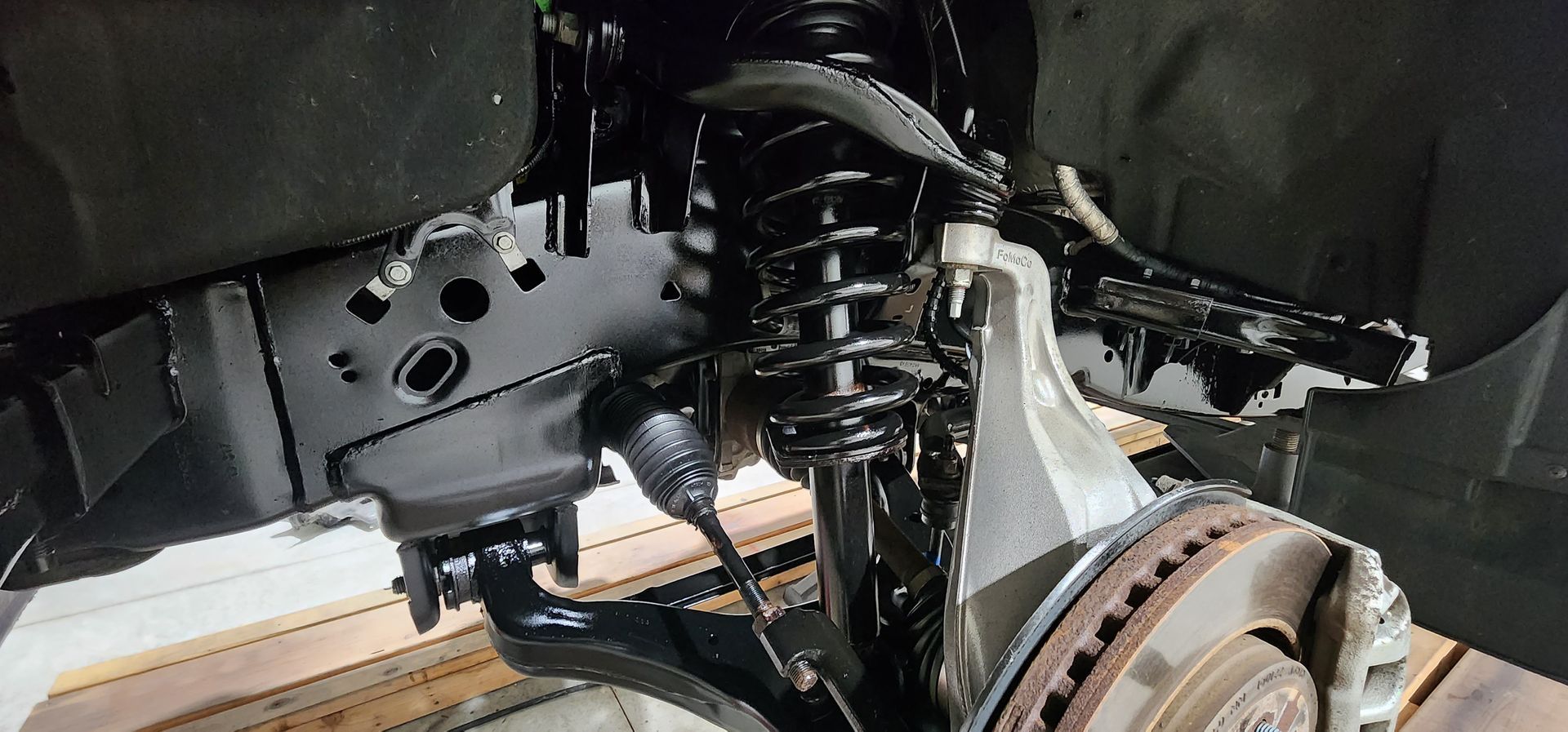 A close up of a shock absorber and a brake disc on a car.