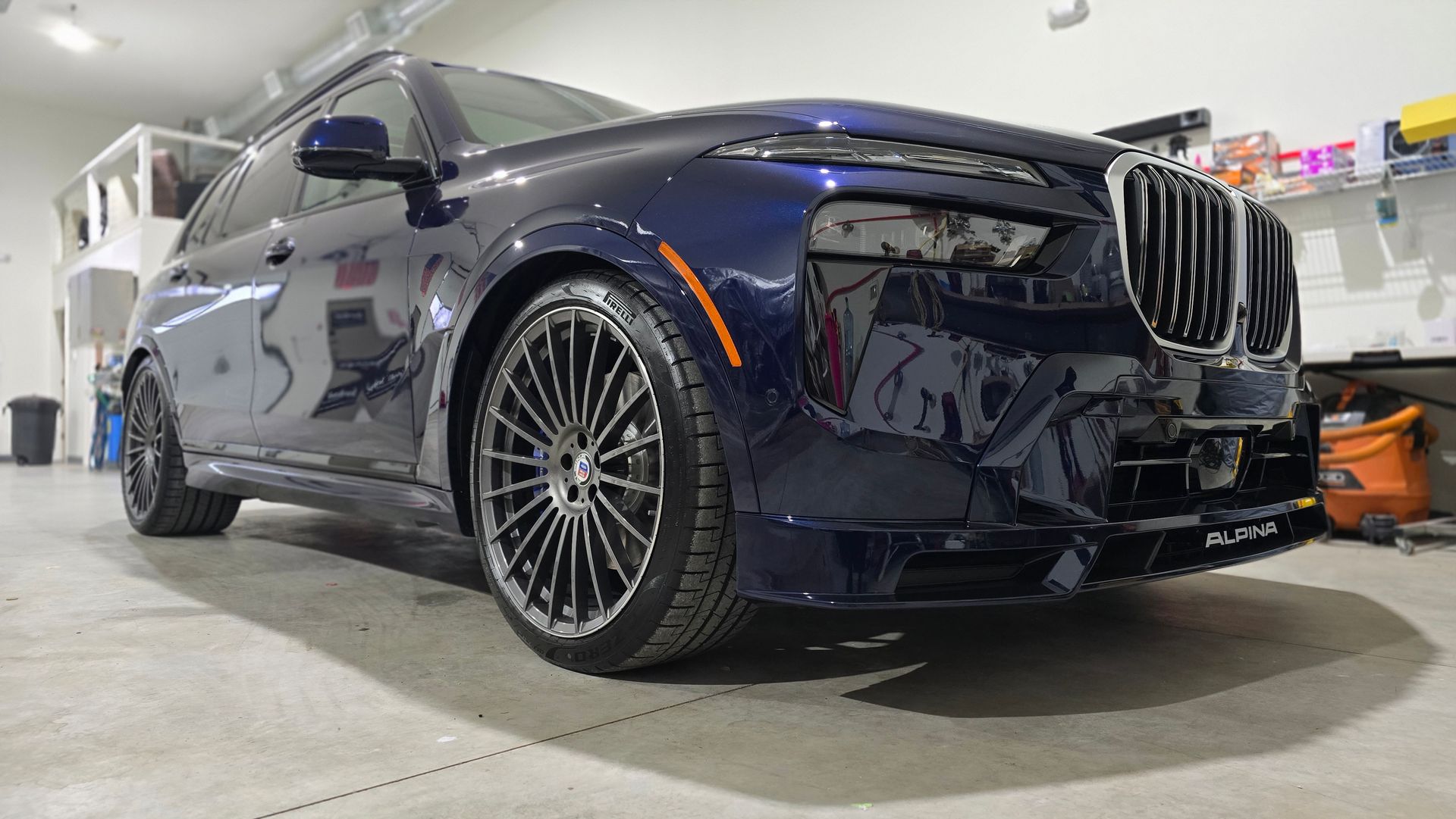 A blue bmw x7 is parked in a garage.