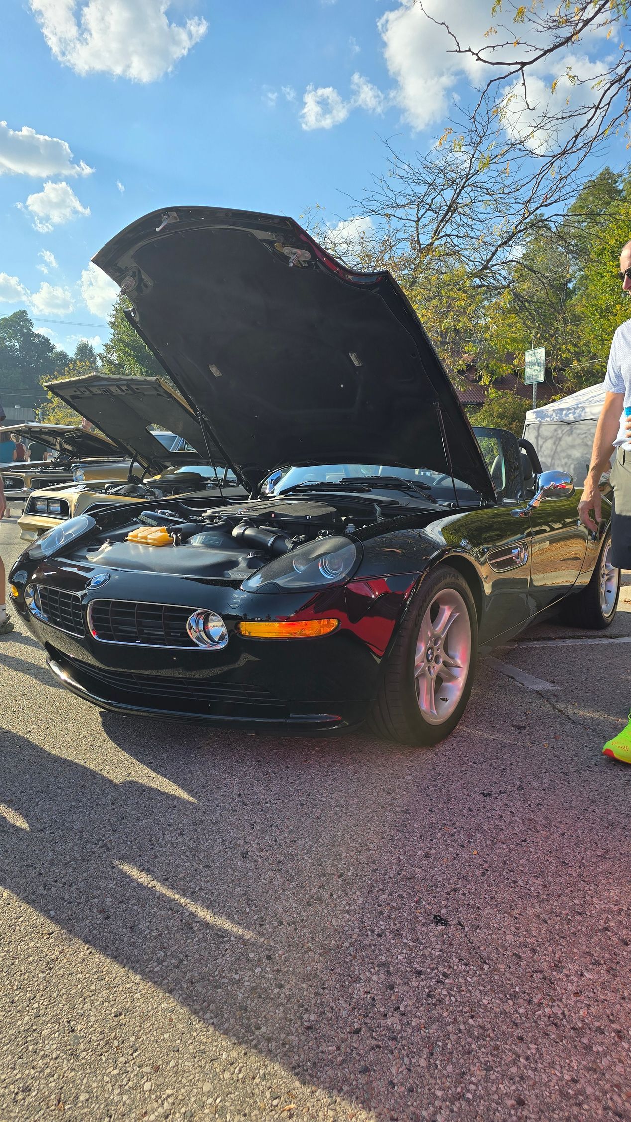 Black BMW Z8 convertible with hood open at an outdoor car show.