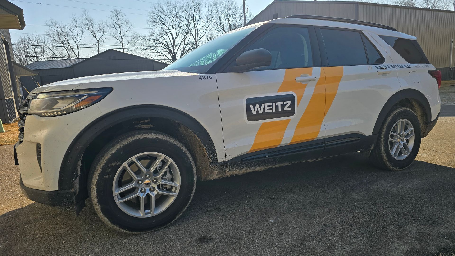 A white SUV with orange stripes and the logo 