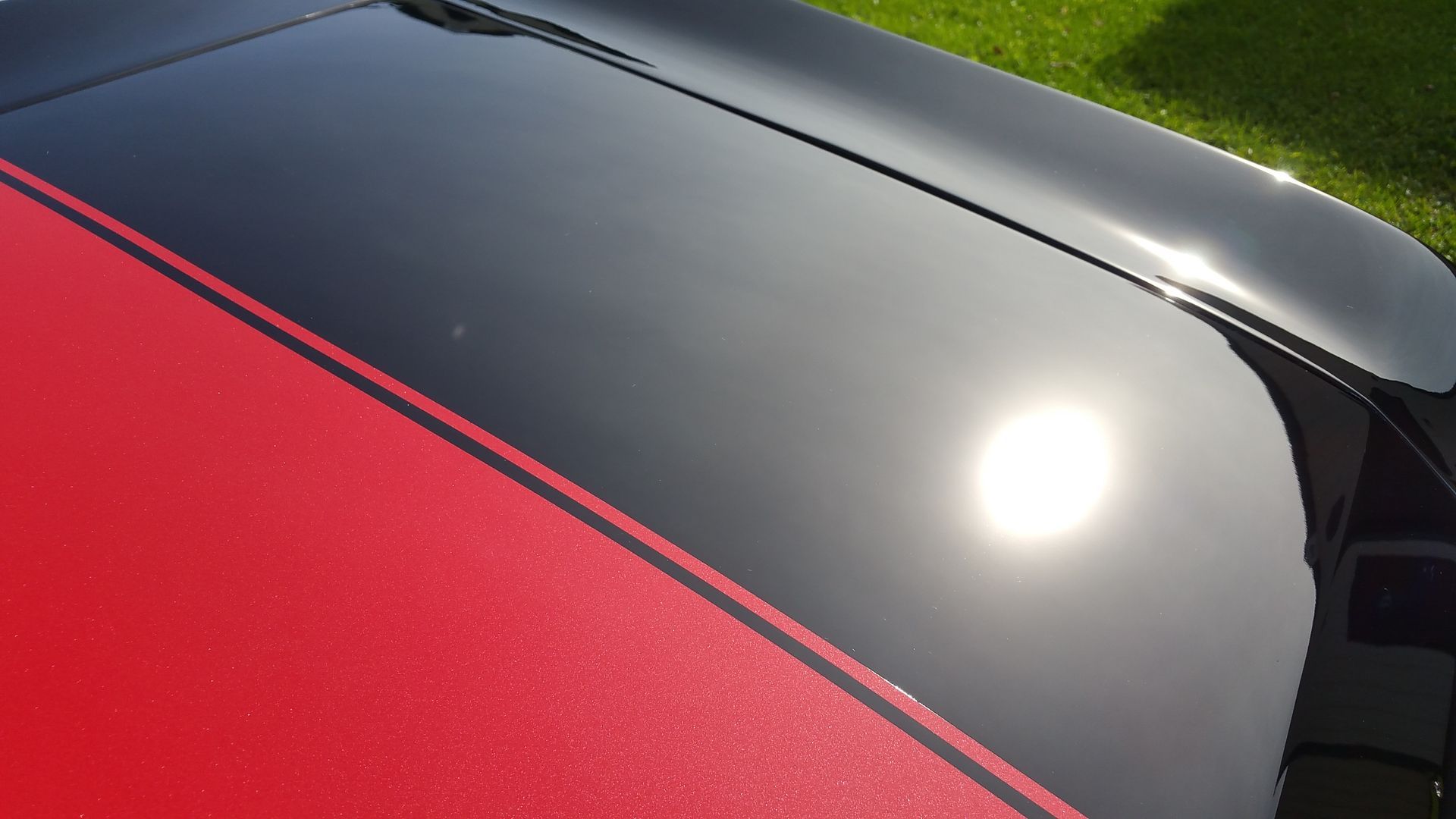 A black car with red stripes on the hood