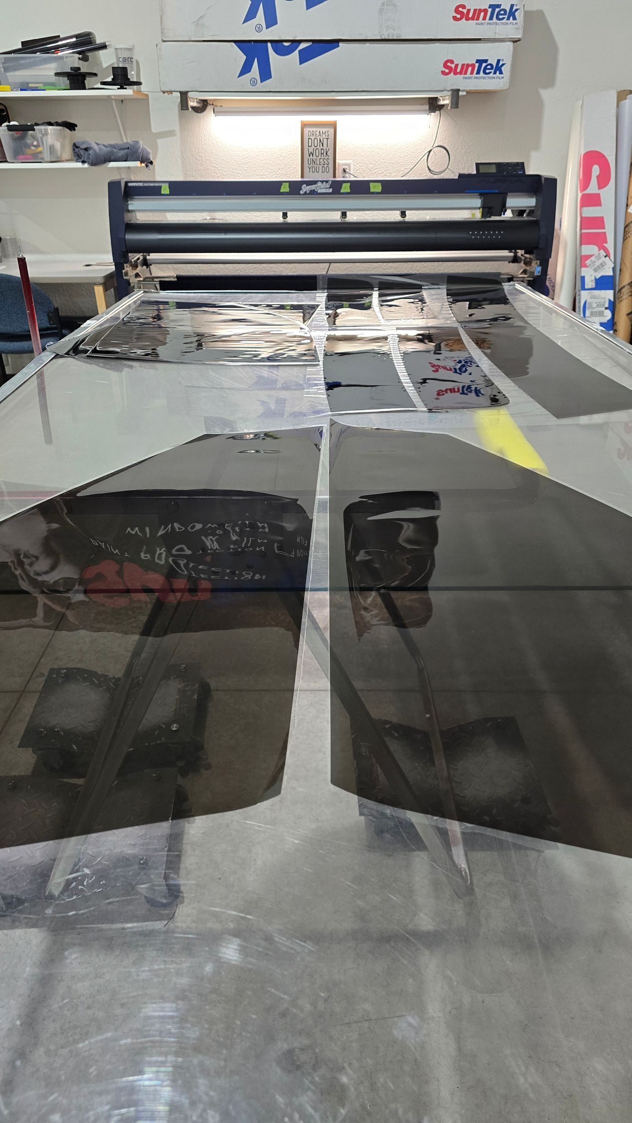 Large format printer in a workshop, printing large sheets of material.