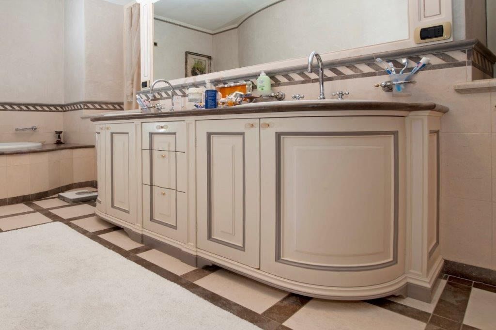 bagno con mobili color crema in legno realizzati su misura