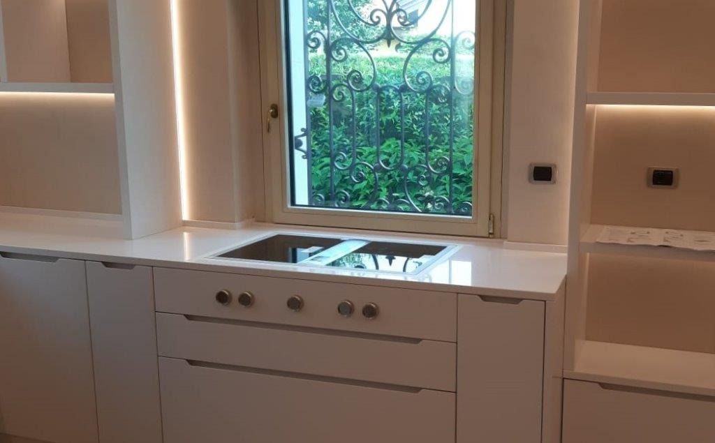 Cucina moderna con mobili bianchi, piano di lavoro in marmo