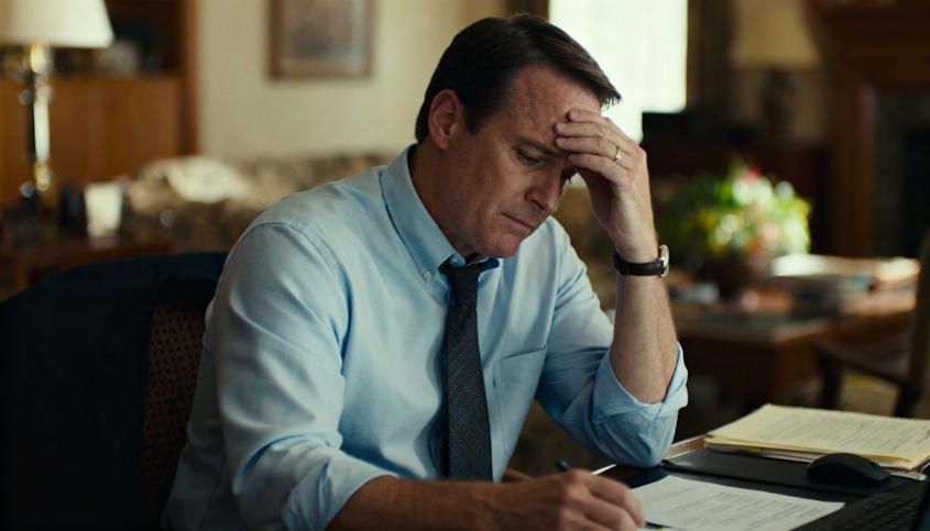 A professional man in Norman at home before getting help, looking burdened by lack of confidence and stress in his home office setting