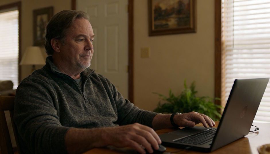 Oklahoma City man relaxing at home during virtual hypnosis session on his laptop