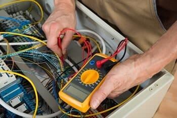 Seattle High Voltage Electric Contractor — Electrician Checking Fuse Box in Burien, WA