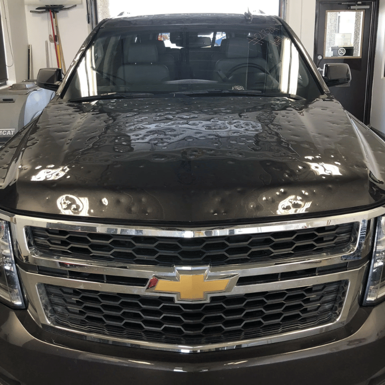 A black chevrolet suv is parked in a garage