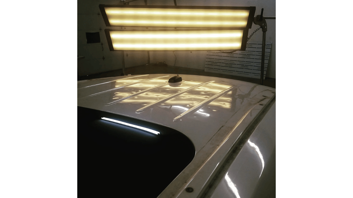 The roof of a car is being repaired with a light.