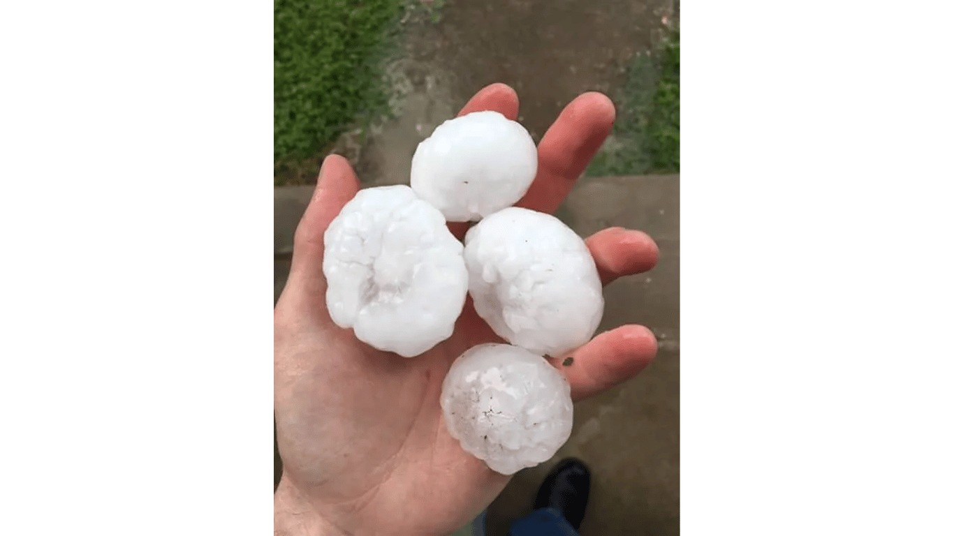 A person is holding a pile of hail in their hand.
