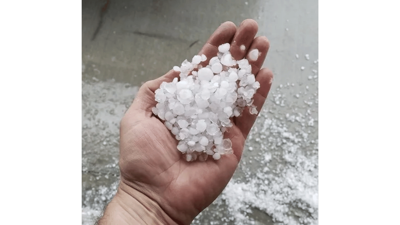 A person is holding a pile of hail in their hand.