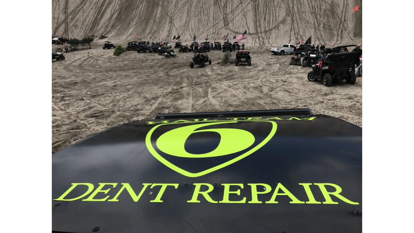 A dent repair logo is on the hood of a vehicle.