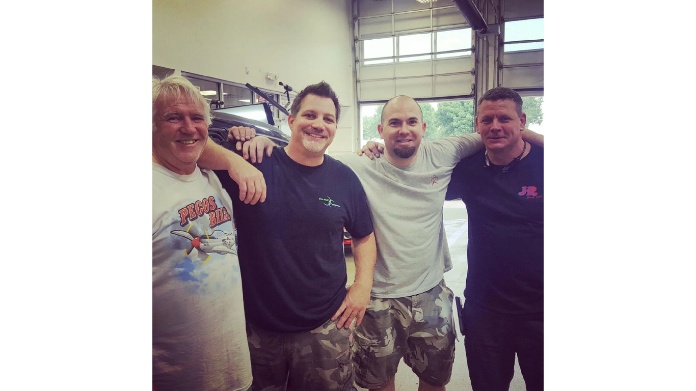 A group of men are posing for a picture in a garage.