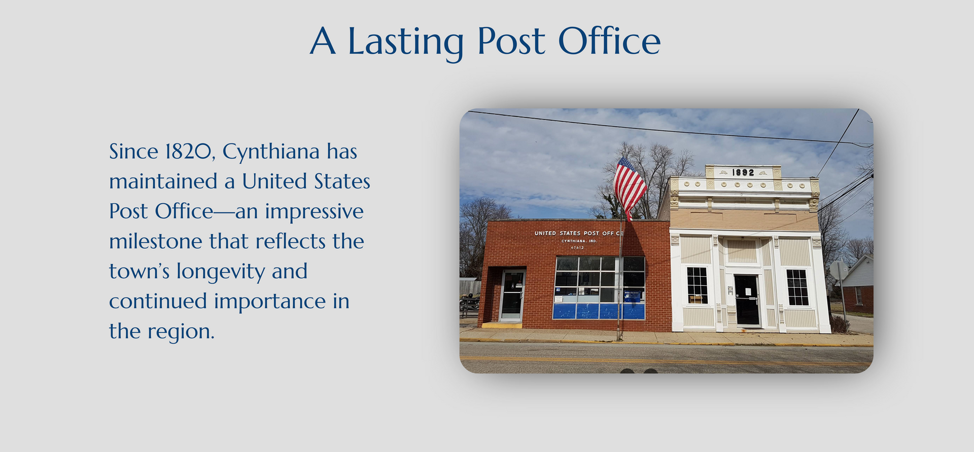 Historic small-town post office with brick storefront and white facade under a blue sky