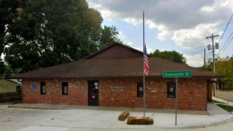 Brick building on a corner with an American flag and a Fannin St sign under cloudy skies