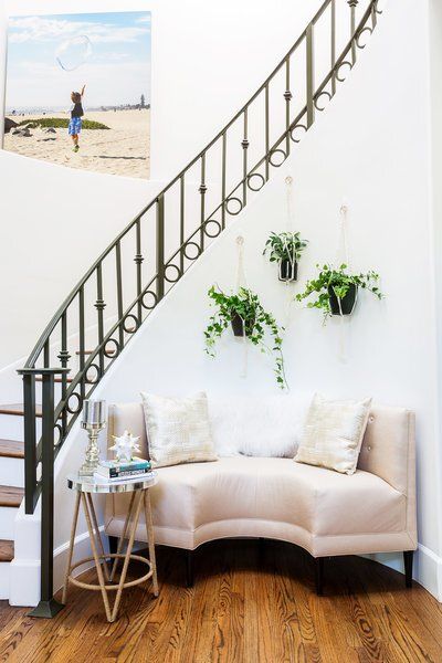 A staircase with a curved couch underneath it