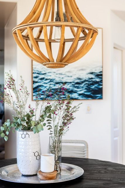 A dining room table with a vase of flowers and a candle on it.
