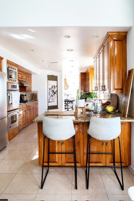 A kitchen with two bar stools and a large island.
