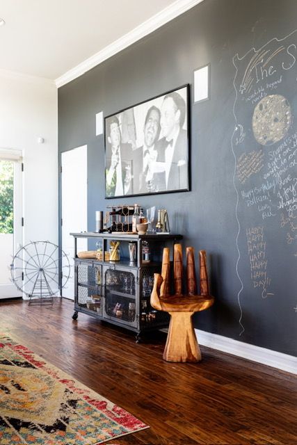 A living room with a blackboard on the wall and a chalkboard on the floor.