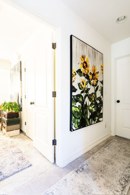 A hallway with a painting of sunflowers on the wall