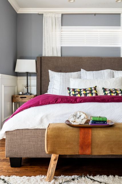 A bedroom with a bed and a bench in front of it