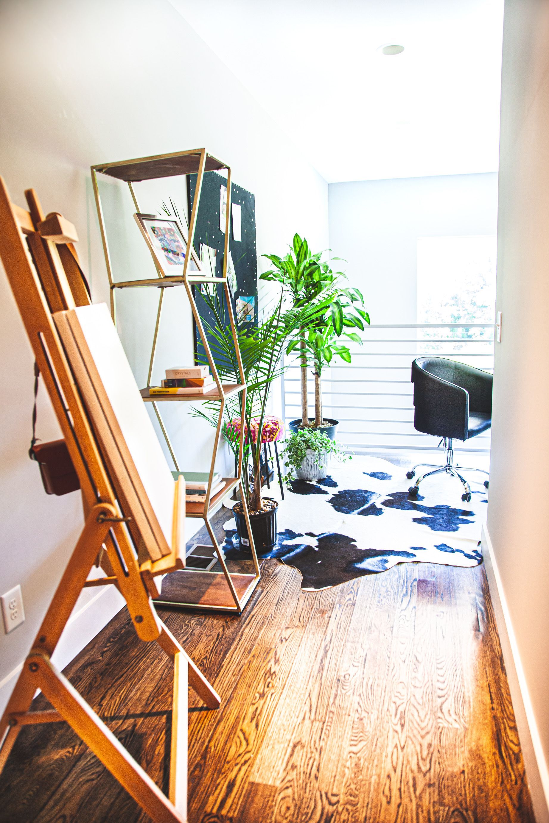 A wooden easel is sitting on a wooden floor in a room.