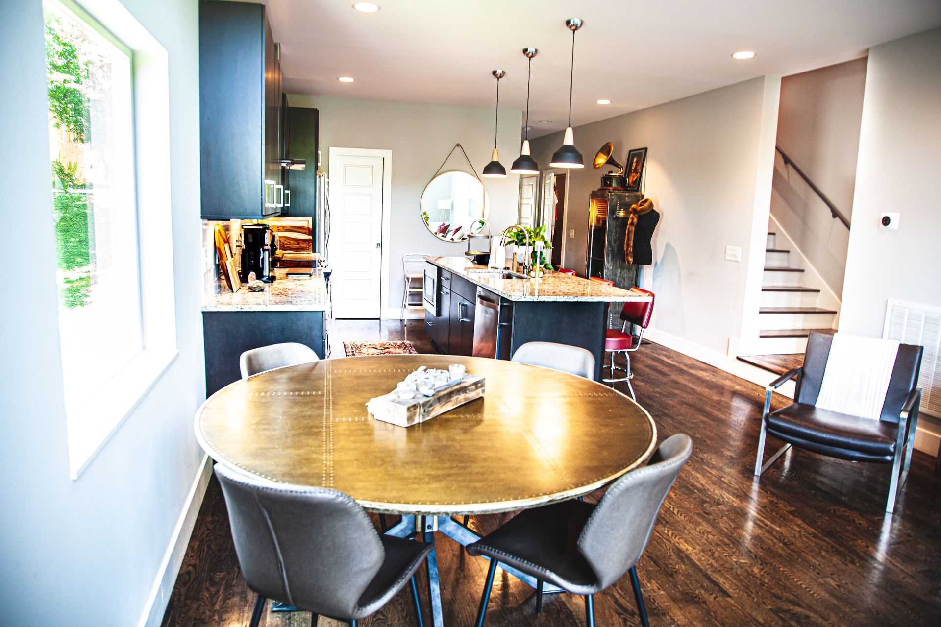 A dining room with a round table and chairs in a house.