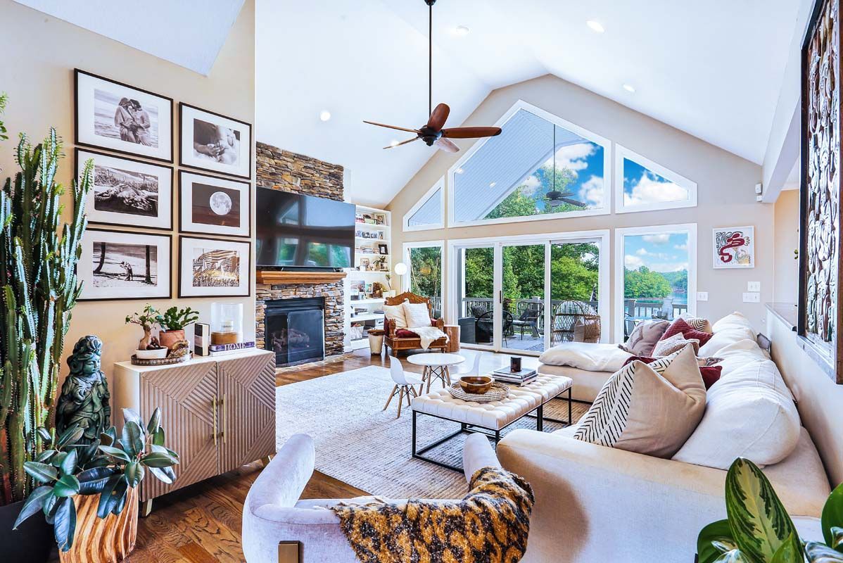 A living room with a couch , fireplace , and ceiling fan.