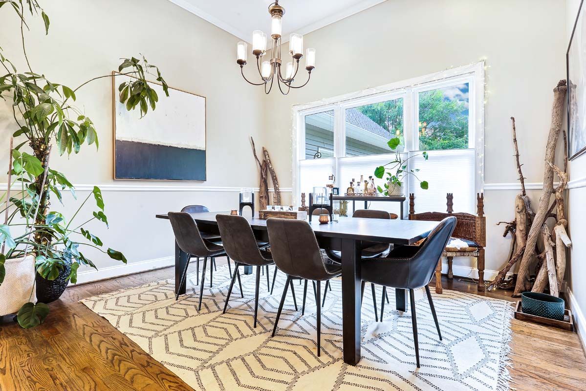 A dining room with a table and chairs and a chandelier.