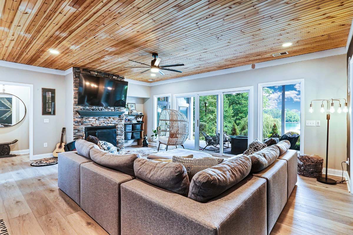 A living room with a large sectional couch and a fireplace.