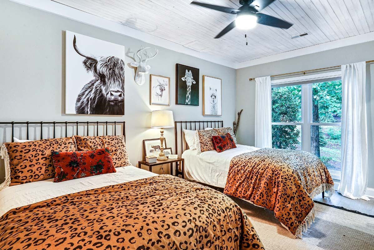 A bedroom with two beds and a ceiling fan.