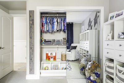 A child 's room with a closet filled with clothes and toys.