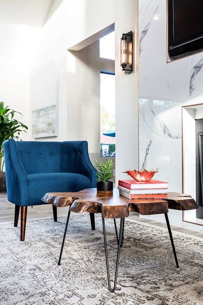 A living room with a blue chair and a wooden table