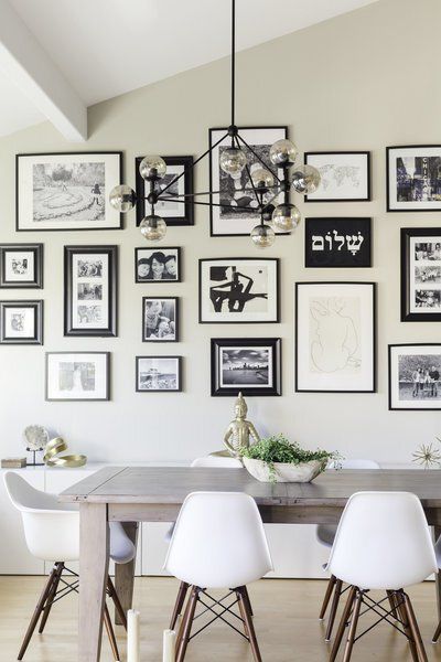 A dining room with a table and chairs and pictures on the wall
