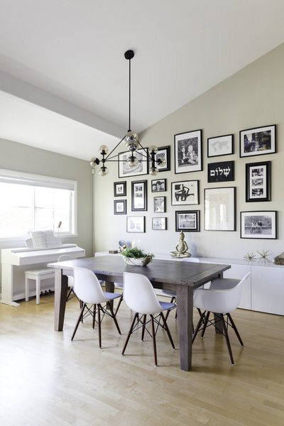 A dining room with a table and chairs and pictures on the wall