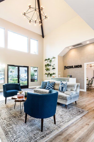 A living room with a couch , chairs , and a chandelier.