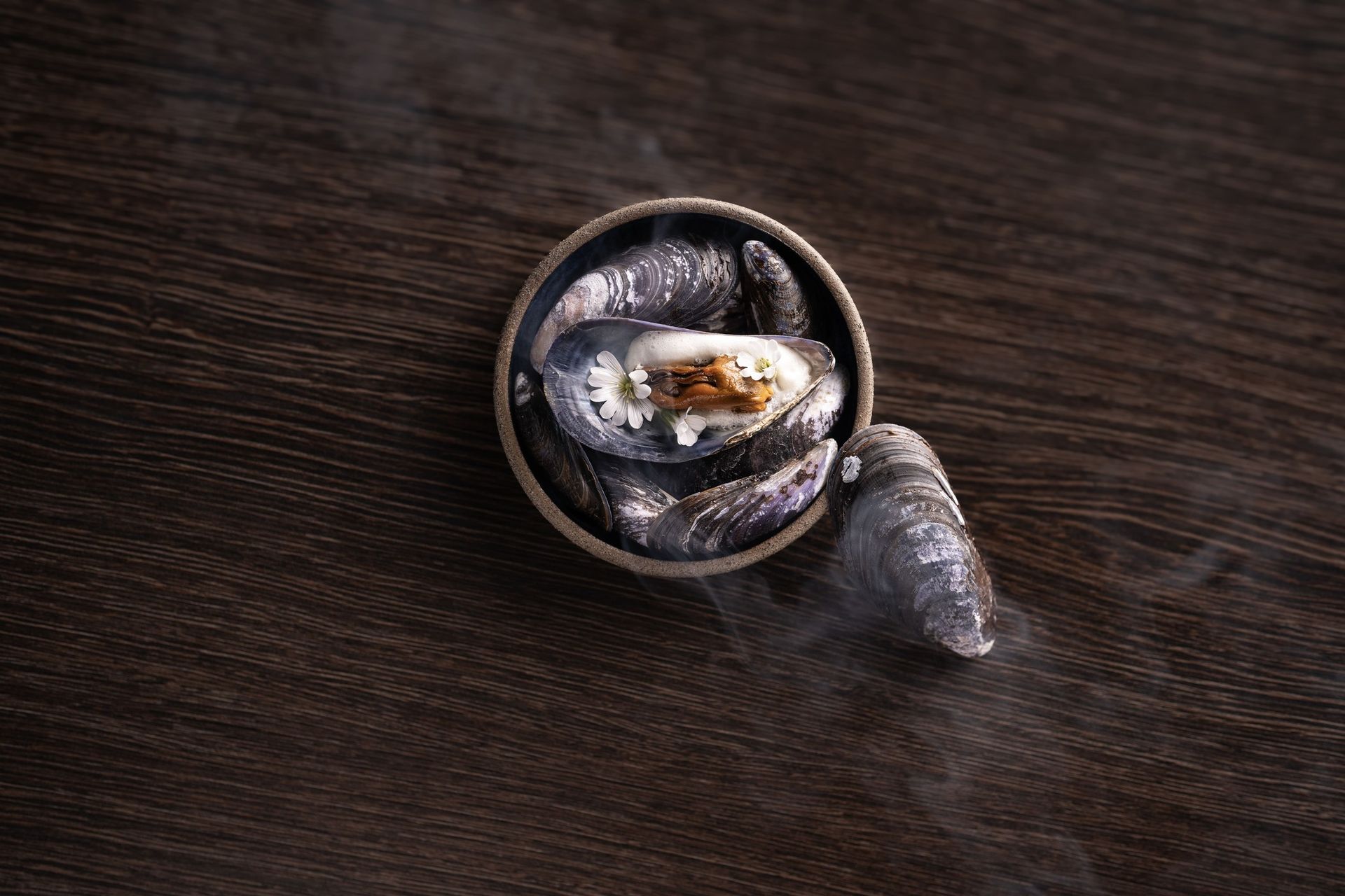 A bowl of food is sitting on a wooden table.