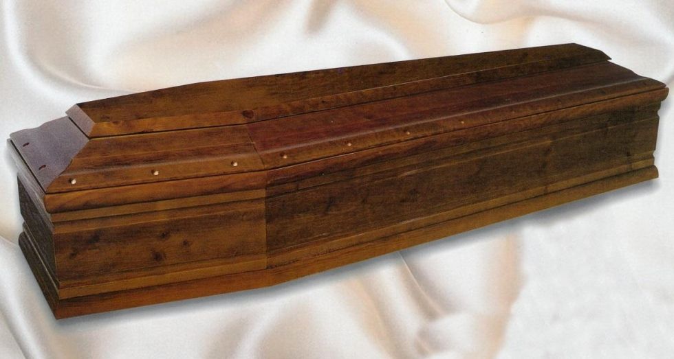 Bara di legno, marrone, appoggiata su una superficie bianca drappeggiata.