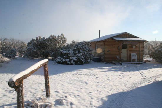 A snowy area with a small house in the background
