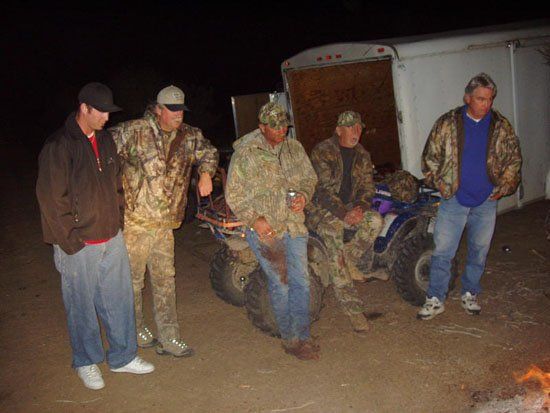 A group of men are standing in front of a trailer
