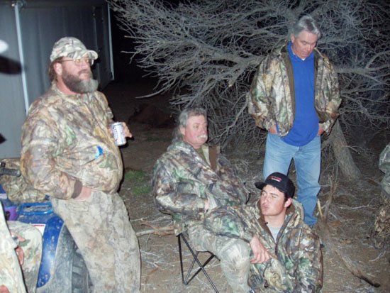A man in a camo jacket is holding a can of beer